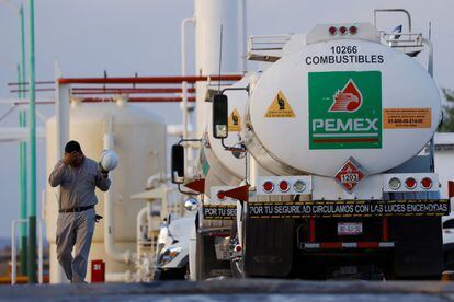 Un trabajador camina cerca de un camión cisterna en un centro de distribución y almacenamiento de combustible de Petróleos Mexicanos (PEMEX) en Ciudad Juárez, México, el 14 de junio de 2022.