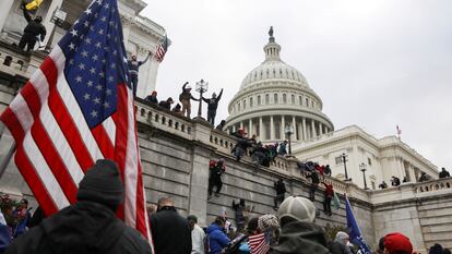 Fieles de Trump trepan por los muros del Capitolio el 6 de enero de 2021. 