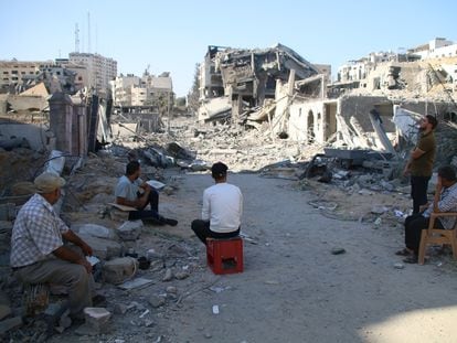 Un grupo de palestinos, ante la destrucción de la ciudad de Gaza por bombardeos israelíes.