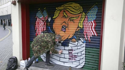 Jack Dones pinta un graffiti de Donald Trump en un comercio de la ciudad brit&aacute;nica de Bristol.