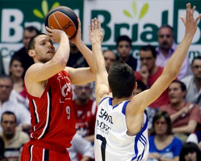 El base belga, Sam Van Rossom lanza a canasta ante la presión del madridista Jorge Sanz.