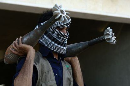 Un rebelde, cargado con dos morteros, en Raqqa, Siria, el 3 de septiembre.