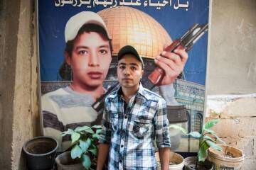 El palestino Mohamed Abu Shaqra, de 24 años, posa delante del retrato de su hermano Imad delante de su casa, al sur del Líbano.