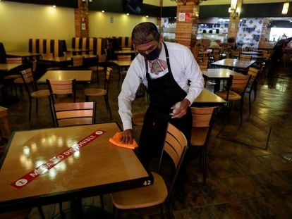 Un mesero limpia una mesa en un restaurante de Ciudad de México.