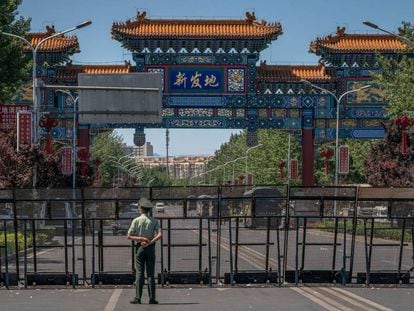 Un policía chino custodia la entrada al mercado Xinfadi, el más grande de Pekín, donde este sábado se detectó un brote de Covid-19.