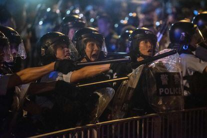 La manifestación, en la que según la Policía hongkonesa participaron 240.000 personas, brillaba este lunes por su ausencia en los medios de comunicación de la China continental. En la imagen policía antidisturbios increpa a los manifestantes.