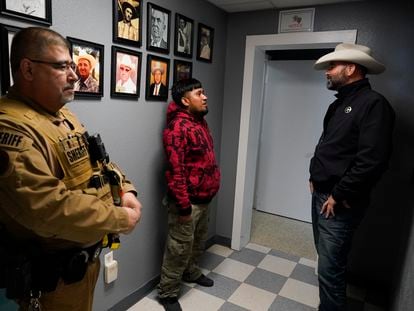 Autoridades del condado de Terrell hablan con un migrante detenido, el 21 de marzo 2024 en Sanderson, Texas.