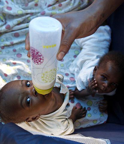 Una cuidadora da de comer a uno de los niños del orfanato Le Coeur de Marie en una tienda de campaña en la calle. El edificio se vino abajo con el terremoto.