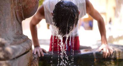 Un joven se refresca en una fuente de la Mezquita de Córdoba.