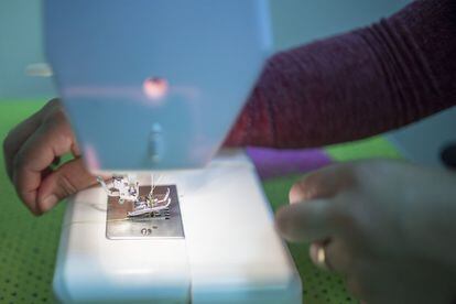 Una de las alumnas del taller de costura coloca un hilo en la máquina de coser básica, comprada en el supermercado Lidl. Las mujeres del taller financiaron esta máquina y algunos materiales elementales con la venta de manualidades en Navidad.