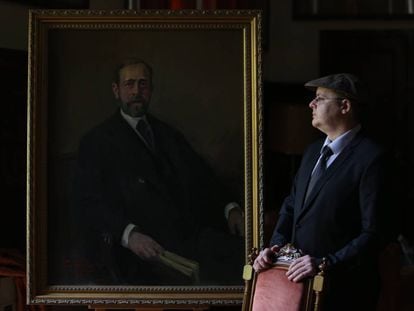 El pintor Alejandro Cabeza junto al &uacute;ltimo retrato que ha pintado, el del ge&oacute;logo Lucas Mallada, en el Museo Geominero de Madrid. 
