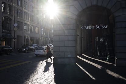 Una mujer caminaba junto a un logo de Credit Suisse en Zúrich el lunes, un día después de ser absorbido por UBS.