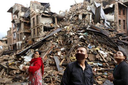 Varias personas inspeccionan los restos de varios edificios destrozados tras el terremoto en el distrito de Bhaktapur (Nepal), 27 de abril de 2015.