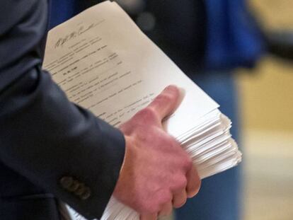 An aide brings the Coronavirus Aid, Relief, and Economic Security Act (CARES Act) to the US Senate chamber at Capitol Hill in Washington, DC, USA, 25 March 2020. EFE/Erik S. Lesser