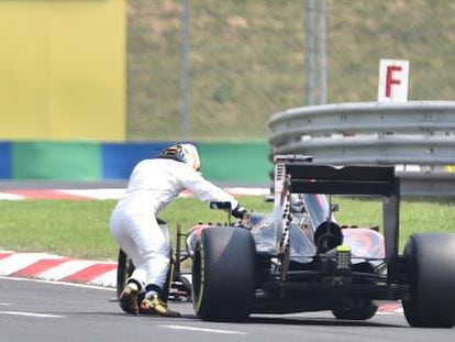 Fernando Alonso empuja su McLaren tras la enésima avería