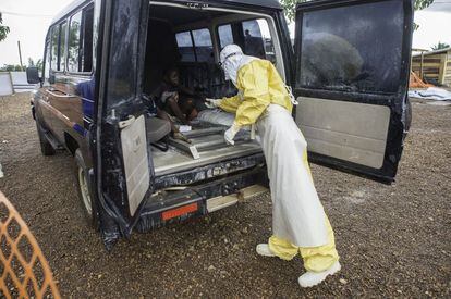 Un doctor de MSF ayuda a un joven paciente, de quien se sospecha que padece Ébola, a salir del vehículo que le ha trasladado al centro de Kailahum.