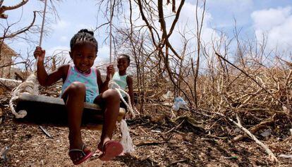 Dos niñas juegan cerca de unos árboles derribados por el huracán Irma en la isla de Anguilla, en el Caribe. / JOE ENGLISH / UNICEF