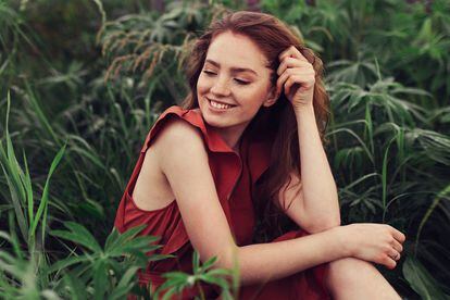 Portrait of laughing young woman with freckles outdoors