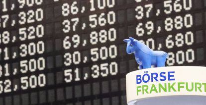 Vista del muñeco de un toro junto a los resultados de los índices en la Bolsa de Valores de Fráncfort.