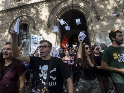 Varios estudiantes salen de la Universidad de Barcelona con papeletas.