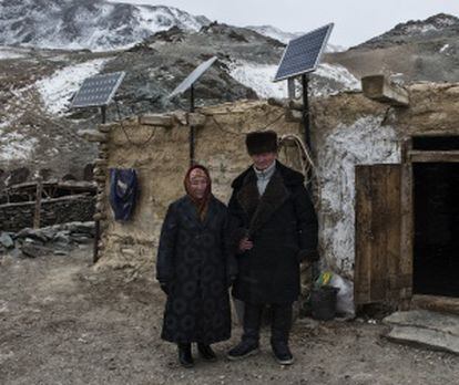 Incluso en las zonas más montañosas del extremo occidental del país, las placas solares han cambiado el ritmo de vida de los nómadas de la etnia kazaja. En la fotografía, Tolhinbai Kenje (izda.) y Uranbai Samat (dcha.) posan bajo las tres placas solares de su casa de invierno. "Es la mejor inversión que hemos hecho", asegura el abuelo.
