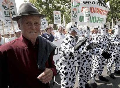 Miembros de la UPA vestidos de vaca junto a un ganadero, en las calles de Madrid.