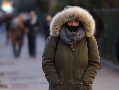 Una mujer pasea muy abrigada contra el frío por Madrid, este jueves.