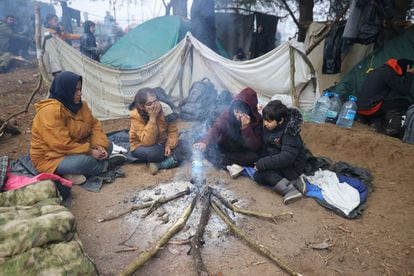 Una familia se calienta junto a una hoguera en el campamento de migrantes situado en la región de Grodno, el 11 de noviembre. Con el objetivo de desestabilizar a la UE, el régimen de Lukashenko aprovecha la vulnerabilidad de emigrantes en zonas como Oriente Próximo y países del Golfo para incentivar el tránsito aéreo hacia Minsk como una vía segura y sin trabas que permite entrar en Europa. De esa forma los potenciales refugiados tienen el aliciente de evitar las peligrosas travesías por mar desde Turquía y desde el norte de África.