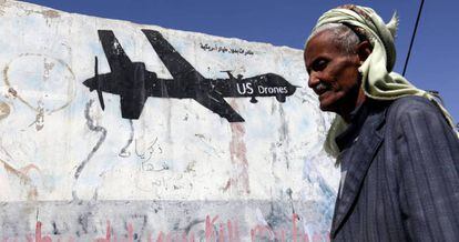 Un yemení pasa junto a una pared en Saná, capital de Yemén, en la que un grafiti protesta contra los ataque aéreos de EE UU.