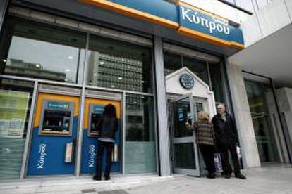 Un hombre retira dinero de un cajero automático de una sucursal del Banco de Chipre en Atenas (Grecia).