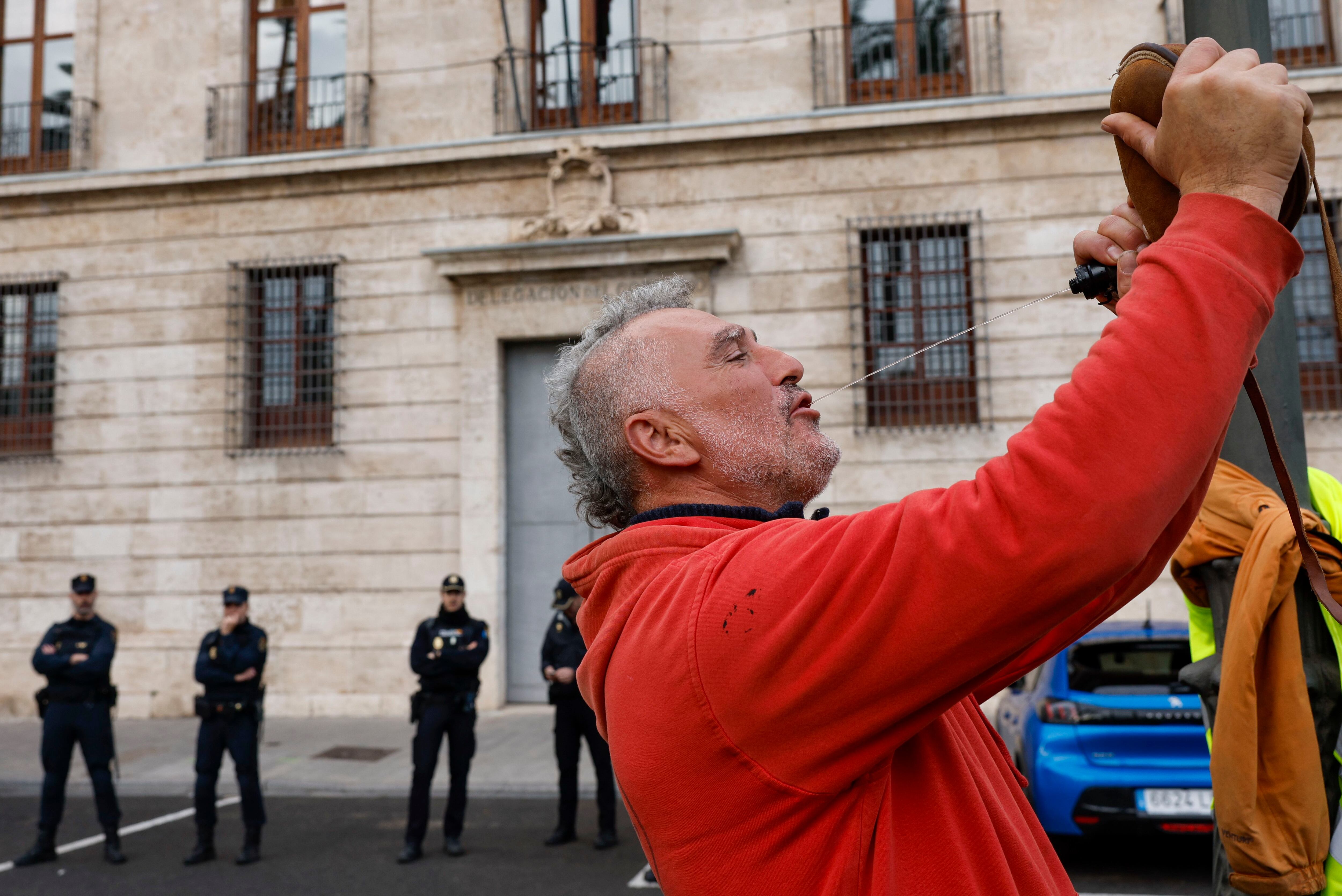 Un vinicultor de la zona de Utiel-Requena bebe vino de un porrón durante la protesta ante la sede de la Delegación del Gobierno en València, el 9 de febrero. 
