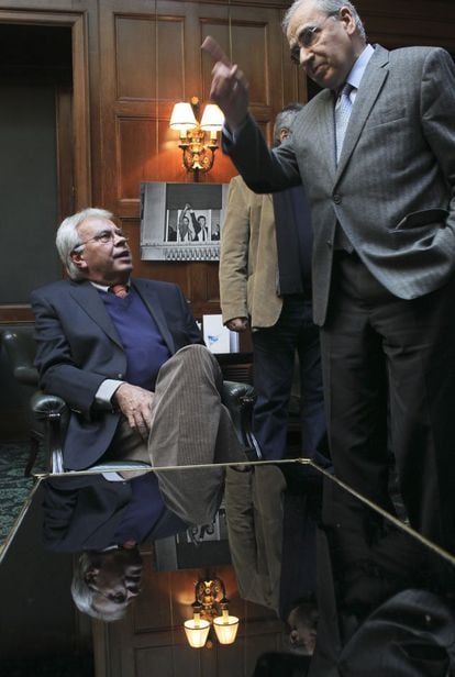 Felipe González y Alfonso Guerra charlan en la cafetería del hotel Palace. Detrás, la foto de César Lucas que inmortaliza la celebración de la victoria electoral de 1982 desde uno de los balcones del hotel.