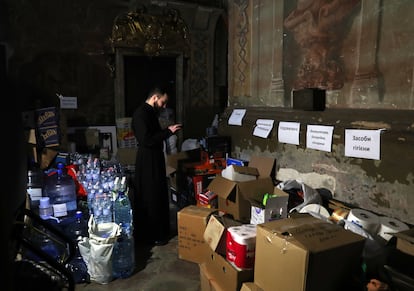 Roman, sacerdote de la iglesia de los Santos Apóstoles Pedro y Pablo, en Lviv, Ucrania, comprueba los alimentos y la ayuda que los fieles han ido dejando durante la semana para los refugiados.
