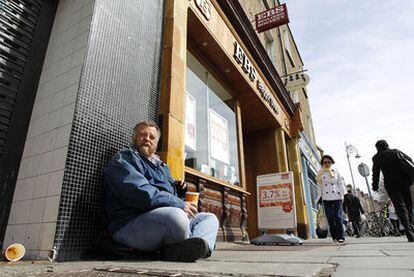 Un hombre pide limosna ante la sede del EBS en Dublín.