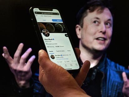 Un teléfono muestra la cuenta de Twitter de Elon Musk sobre una foto del empresario.
