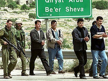 Dos soldados israelíes escoltan a varios palestinos maniatados, detenidos durante las operaciones militares en Belén.