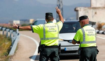 Un agente de la Guardia Civil de Tráfico da el alto a un vehículo durante un control de velocidad. 