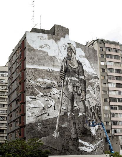Este mural no es uno más de los muchos que se despliegan por São Paulo, ciudad brasileña que concentra uno de los mayores museos de arte urbano al aire libre. Con una superficie de 1.000 metros cuadrados sobre una fachada del centro, 'El brigadista de la selva' está hecho con pintura realizada con más de 200 kilos de las cenizas de los incendios que azotaron cuatro zonas del país: la Amazonía, el Pantanal, el Cerrado y la Mata Atlántica. El artista y activista Thiago Mundano reinterpreta la obra 'Labrador de café', de Cándido Portinari, sustituyendo al granjero por la figura de Vinícius Curva de Vento, un brigadista voluntario al que conoció en el Cerrado. Se trata de “acercar aquello que está lejos de la ciudad y generar empatía”, asegura Mundano. Su trabajo contrasta con los coloridos murales del resto de la ciudad, pero su arte, dice, no busca embellecer, sino provocar en las personas cambios internos.