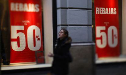 Una joven pasa por delante de un comercio con rebajas en el centro de Madrid, el 4 de enero 2016.