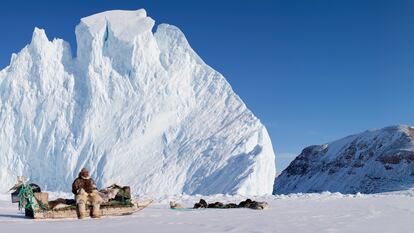 Un hombre inuit, con su canoa y sus perros.
