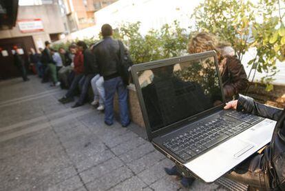 Una oficina de empleo en Madrid. Un joven busca ofertas laborales en su ordenador mientras espera la cola, una opción muy extendida.