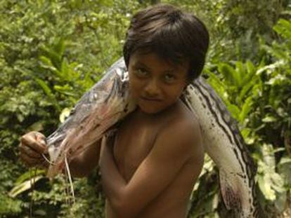 Un niño porta un pescado en Yasuní, cerca del río Napo.