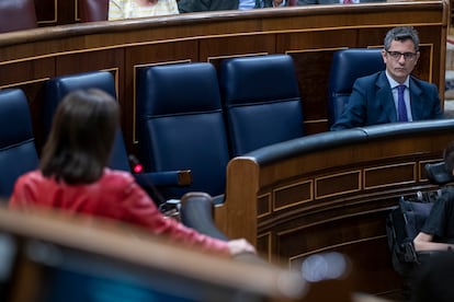 La ministra de Defensa, Margarita Robles, de espaldas, y el ministro de Presidencia, Félix Bolaños, en el hemiciclo del Congreso.