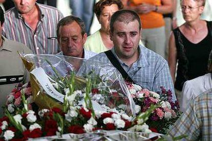 Un familiar de la mujer hallada muerta en Almería, acompaña el féretro a la salida del funeral.