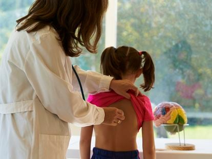 Una pediatra pasa consulta a una niña.