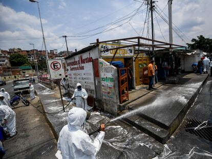 Trabajadores municipales desinfectan las calles del barrio de Petare, en Caracas.