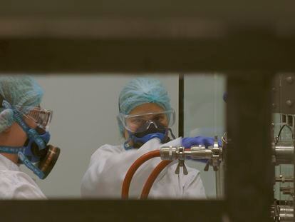 Dos empleados del Centro Militar de Farmacia de la Defensa produciendo gel hidroalcohólico.