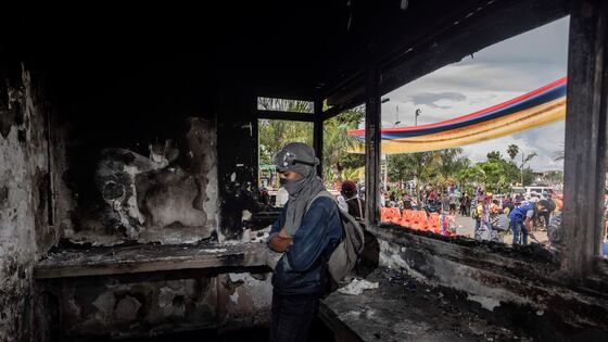 Un joven monta guardia en el interior de una estación de Policía que fue quemada por los manifestantes en Puerto Resistencia, Cali, este miércoles.