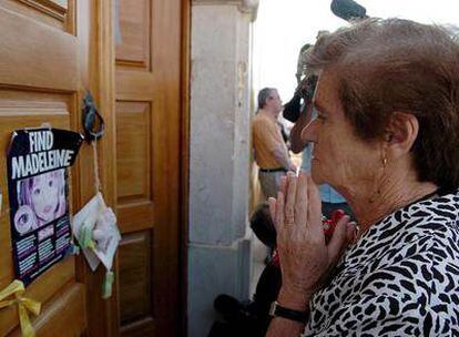 Una mujer reza frente a la puerta de la parroquia de Lagos, donde el sábado se celebró una misa por Madeleine.