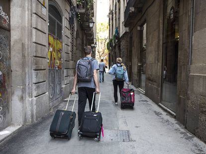 Turistas con maletas en el distrito de Ciutat Vella de Barcelona.